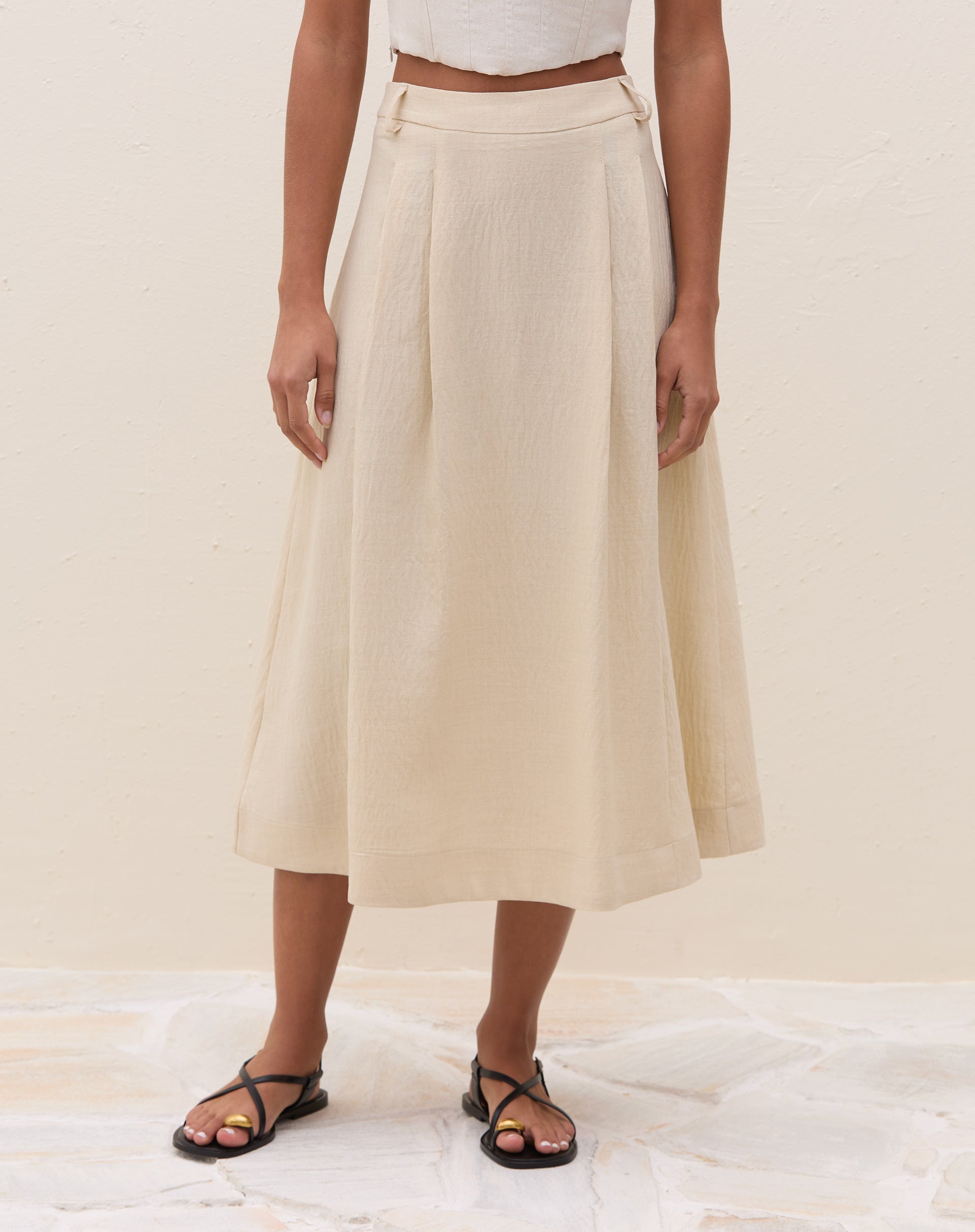 Vista traseira da saia midi off-white com pregas.