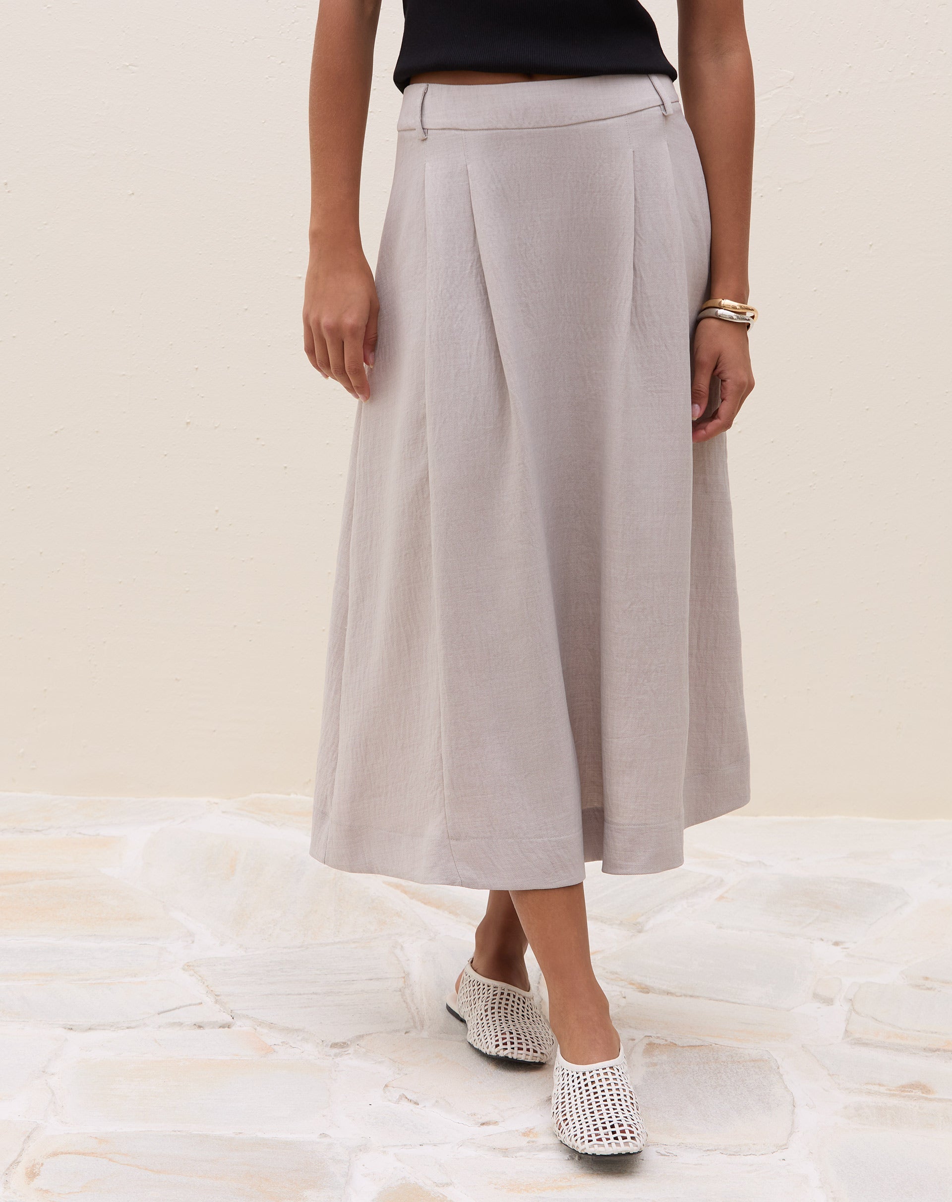 Vista frontal da saia midi cinza claro com pregas.