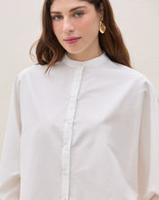 Detalhe da gola padre e fechamento com botões da camisa oversized.