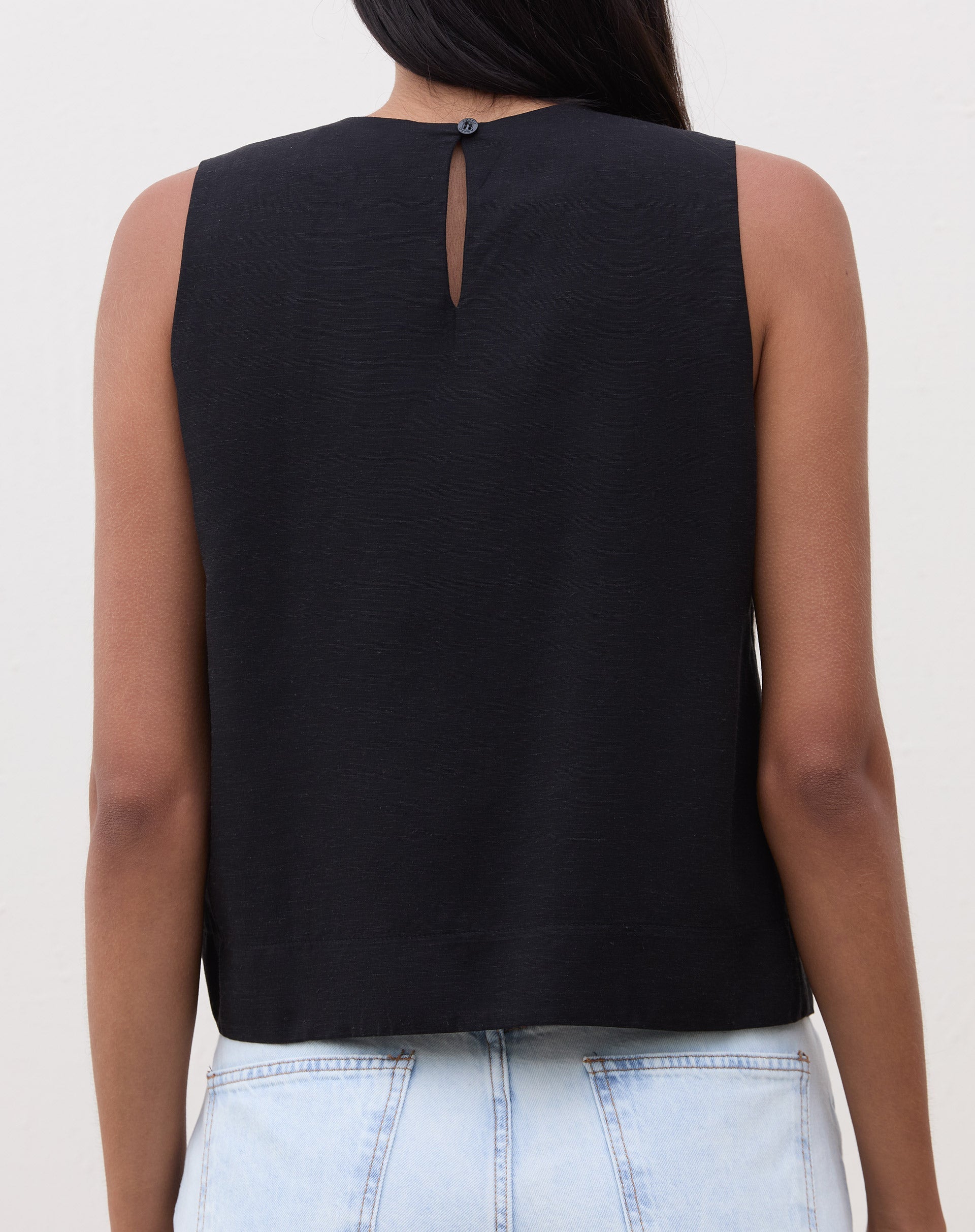 Vista traseira da regata preta mostrando o fecho em formato de gota.