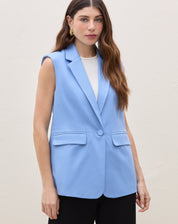 Imagem de um colete de alfaiataria azul médio com ombreira, sem mangas e decote em V.