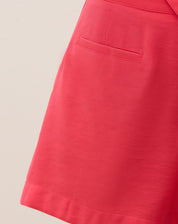 Close-up do bolso embutido do short coral.