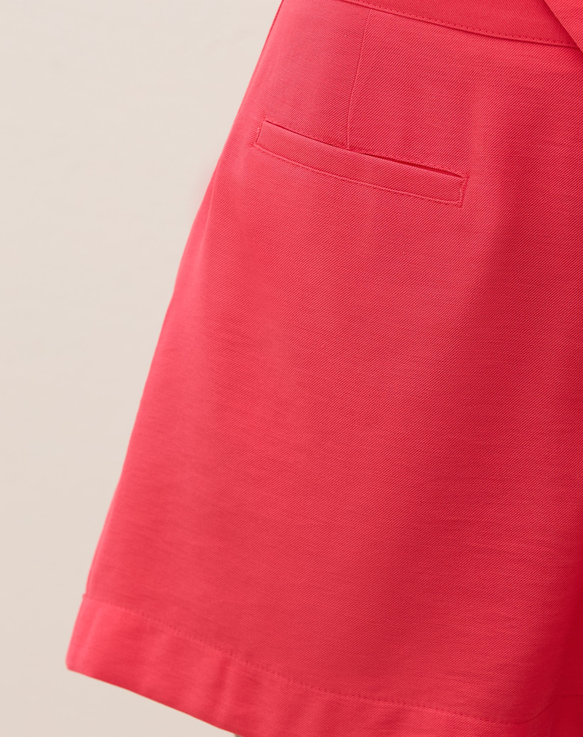 Close-up do bolso embutido do short coral.