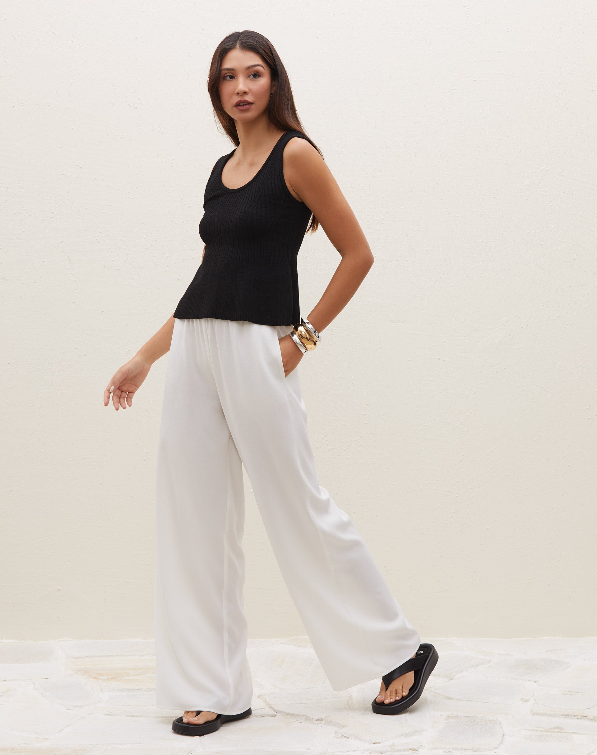 Blusa preta de tricot com decote U, sem mangas, vista lateral.