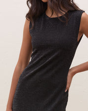 Close-up do vestido midi preto com fenda, destacando o tecido com lurex.