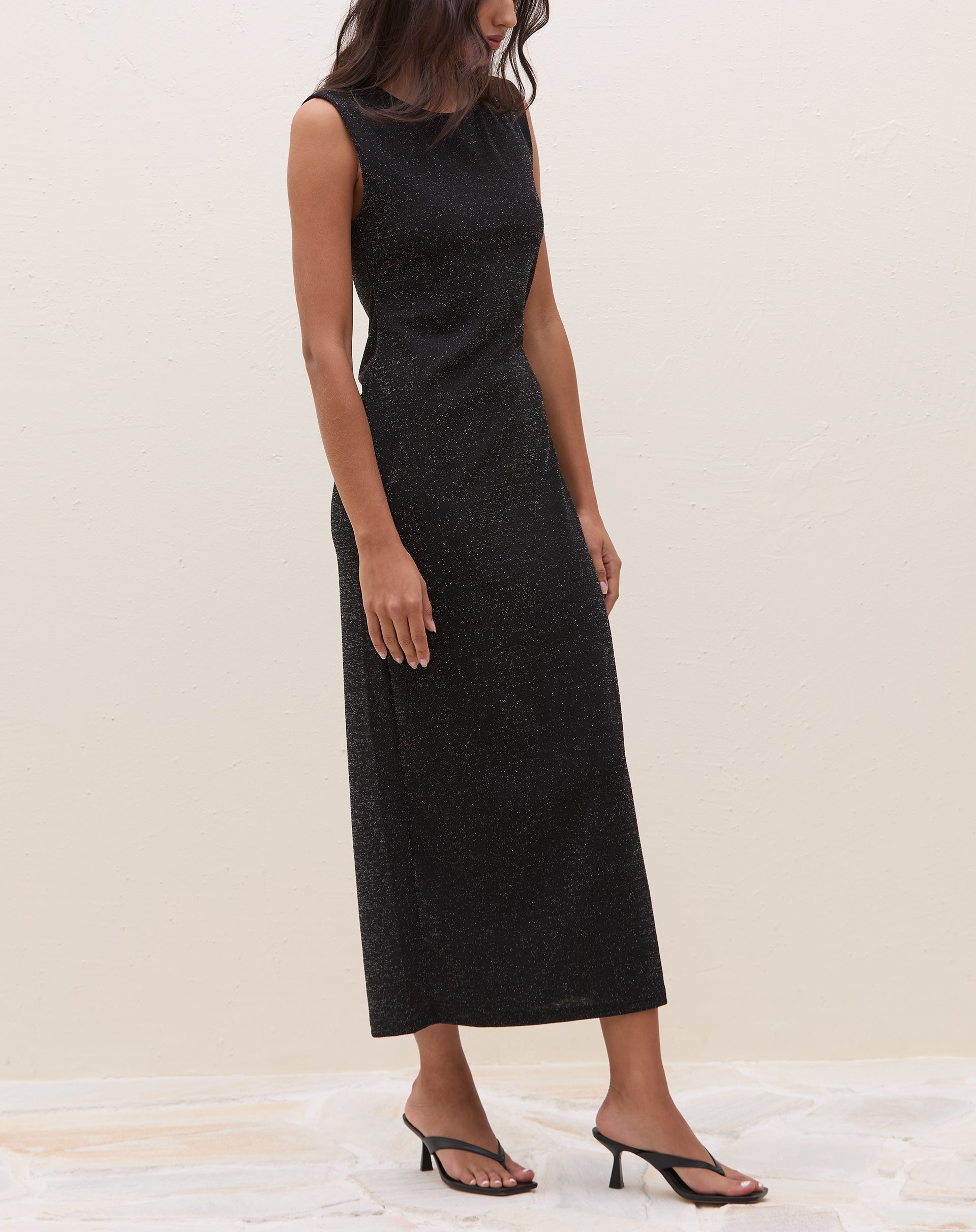 Vista traseira do vestido midi preto com fenda, mostrando o detalhe do fecho.