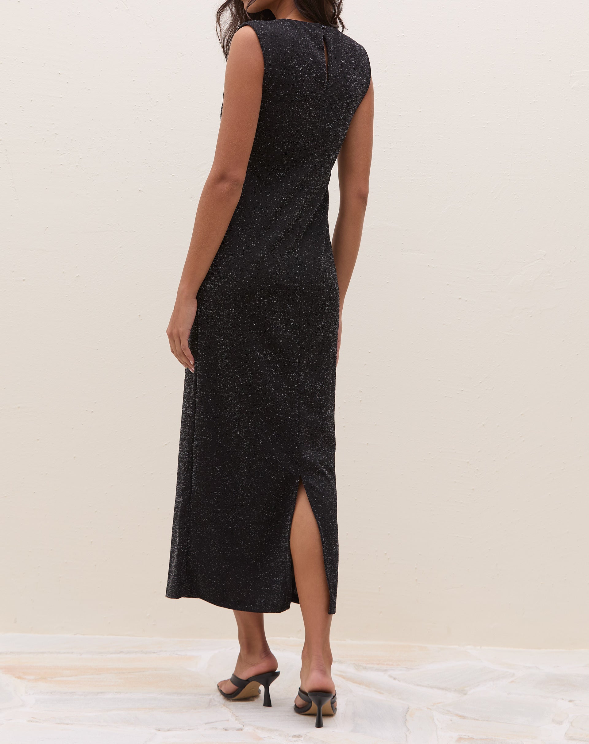 Imagem do vestido midi preto com fenda em fundo branco, mostrando o design completo.