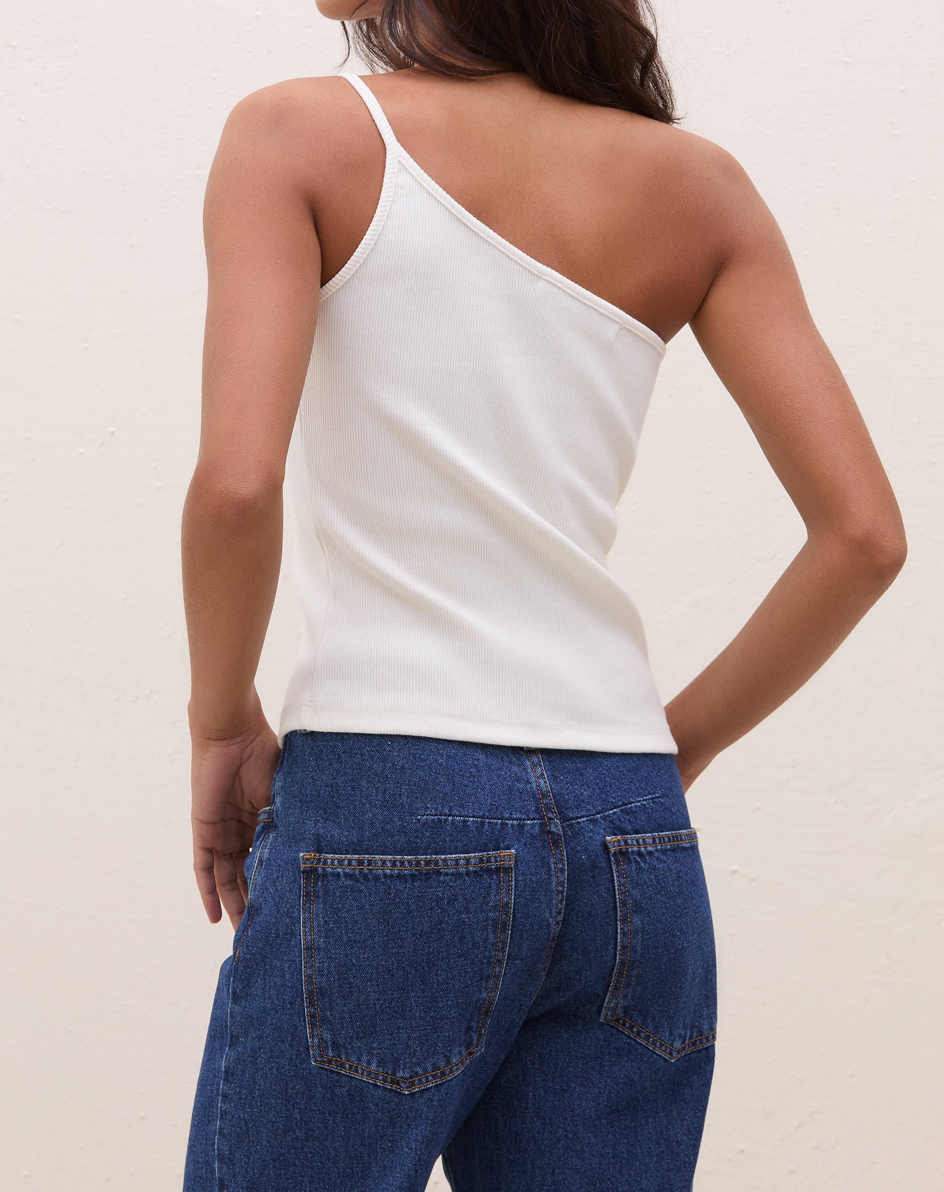 Vista traseira da blusa um ombro só de ribana power off-white, destacando o design assimétrico.