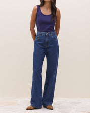 Modelo vestindo body azul marinho com calça jeans, mostrando o look completo.