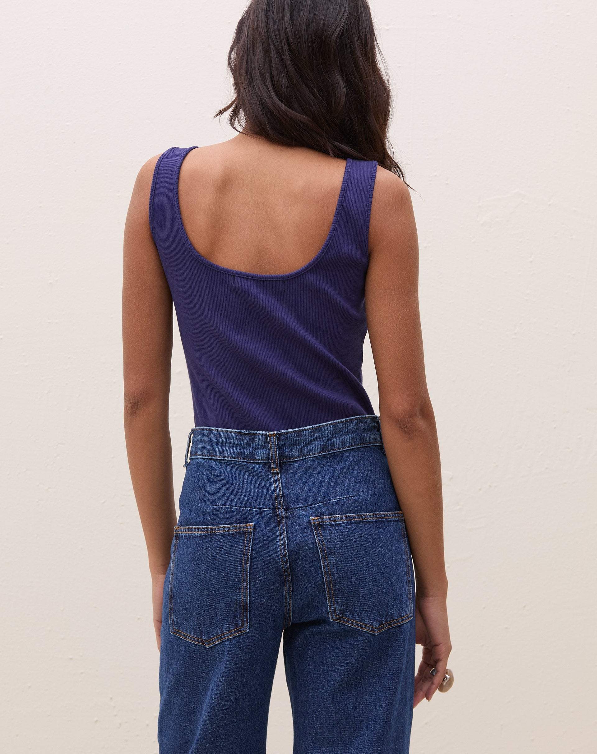 Vista traseira do body azul marinho com alças largas.