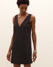 Detalhe do decote V do vestido curto preto.