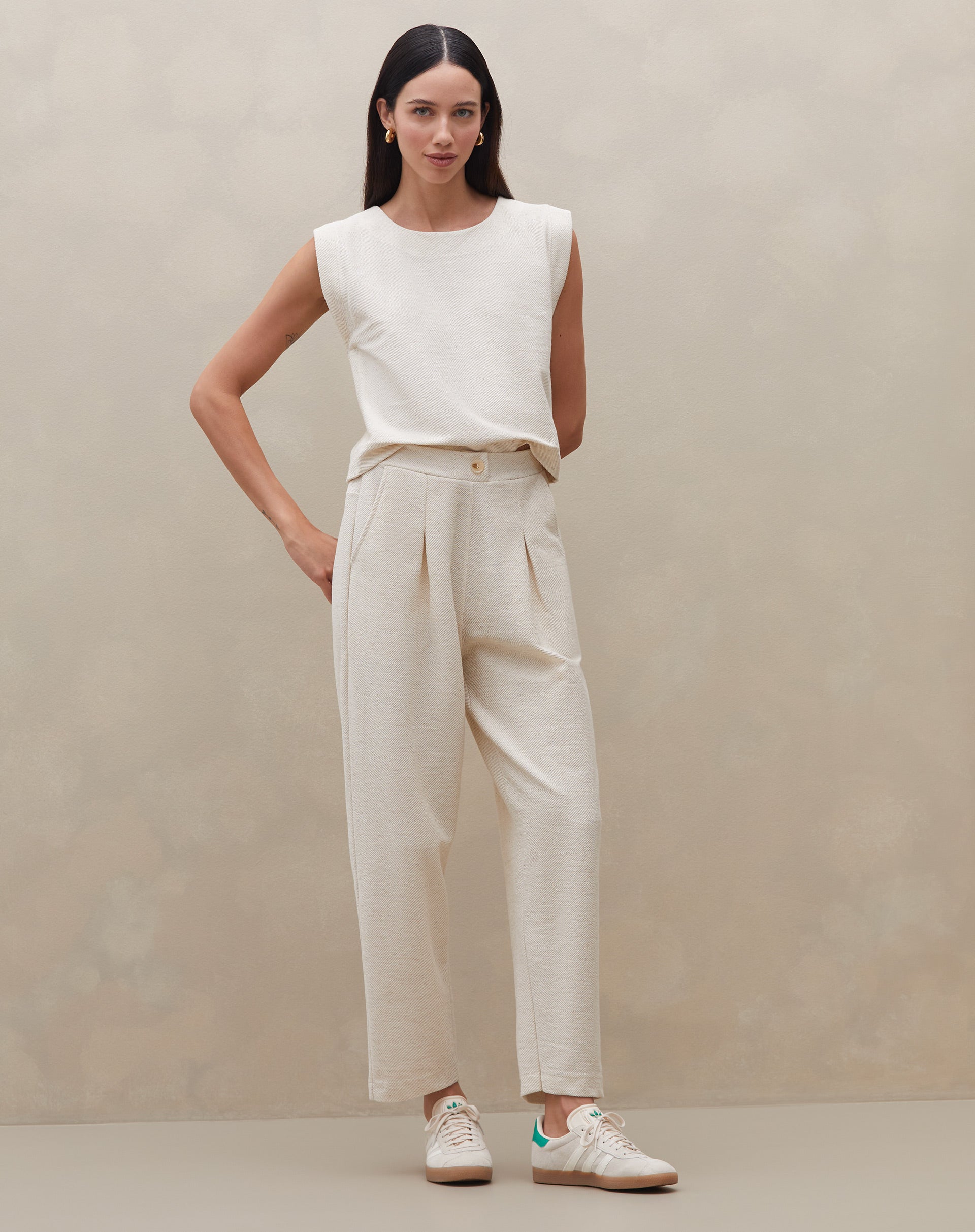 Modelo vestindo calça de cintura alta em malha texturizada, vista frontal.