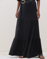 Detalhe da parte inferior do vestido longo preto com recortes de malha.