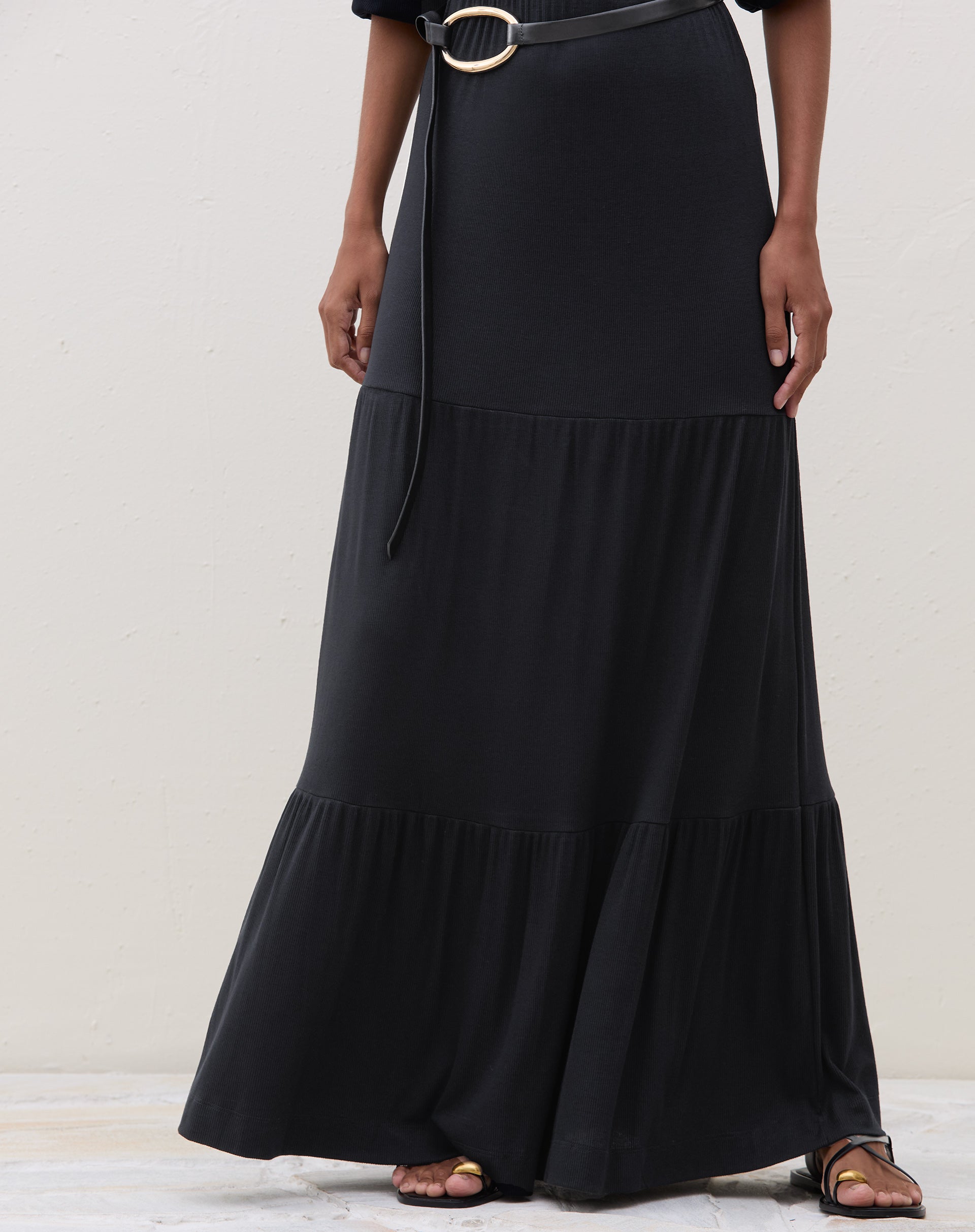 Detalhe da parte inferior do vestido longo preto com recortes de malha.