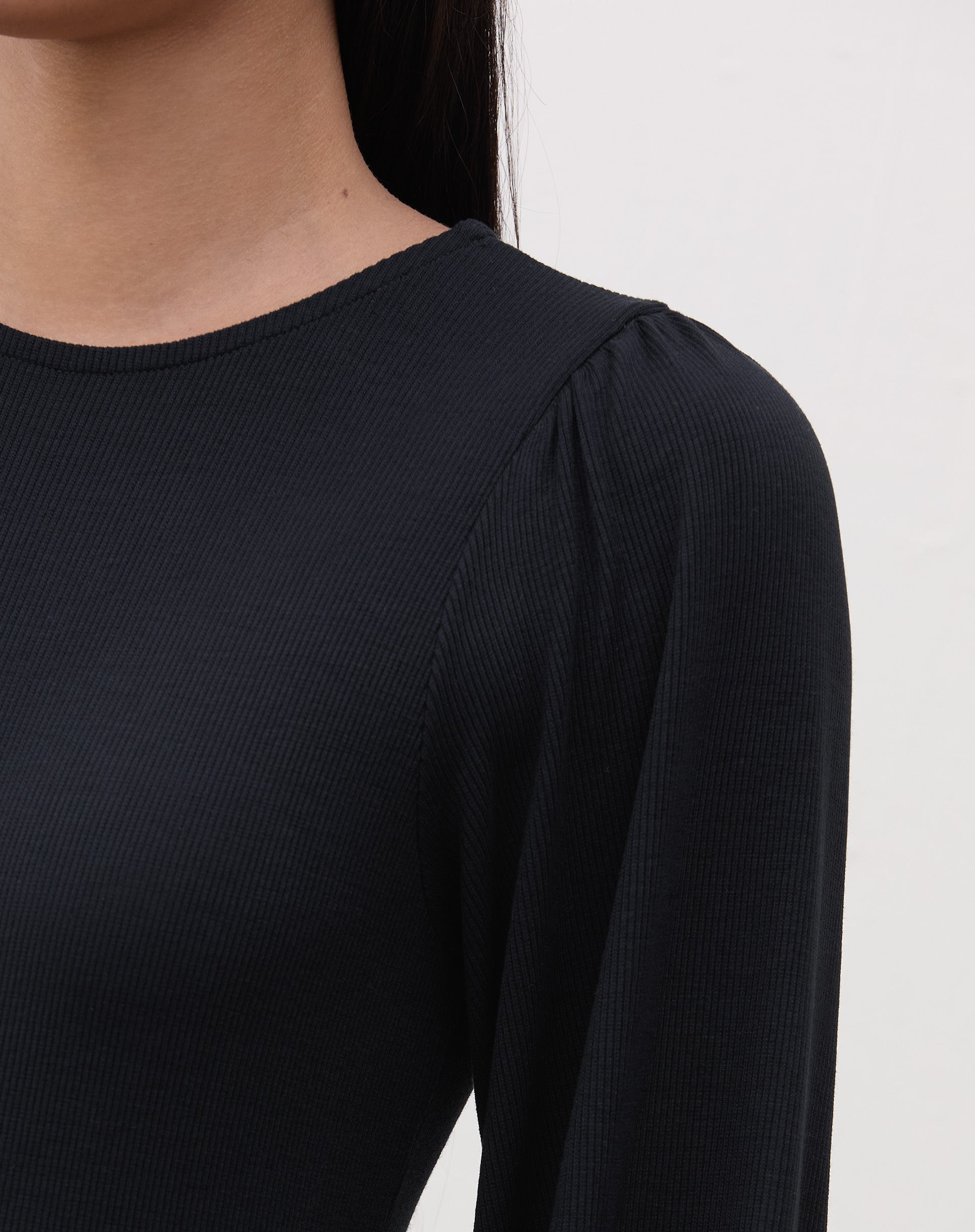 Vista lateral do vestido longo preto com recortes de malha.