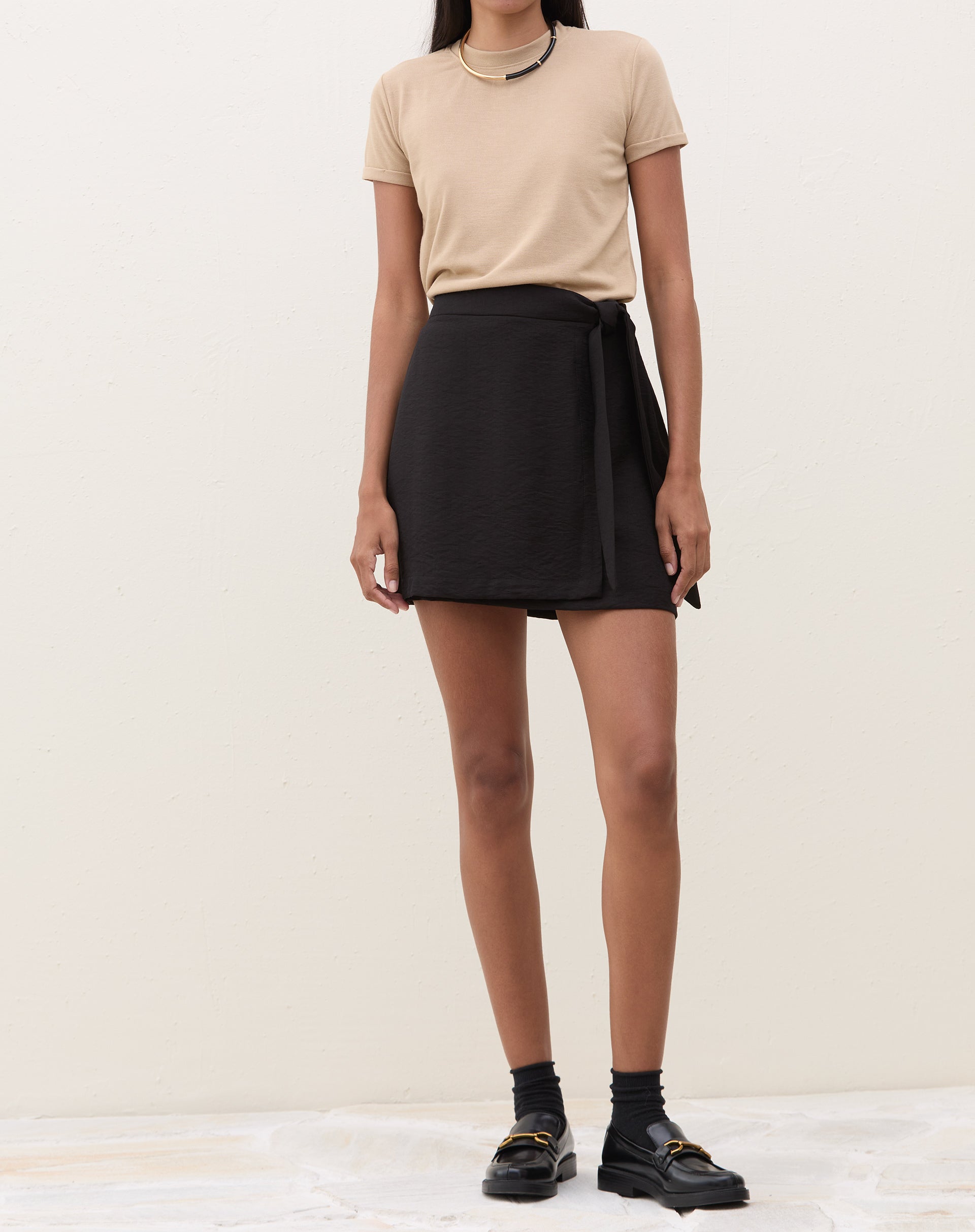 Vista traseira da camiseta de malha bege.