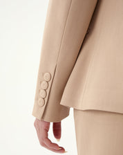 Detalhe de punho do blazer exibindo quatro botões decorativos e costura refinada.