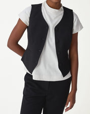 Colete alfaiataria slim preto sem mangas com botões forrados, close frontal mostrando bolsos passpa e caimento ajustado.