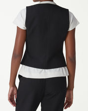 Vista traseira do colete alfaiataria preto em modelo, evidenciando corte ajustado e comprimento midi.