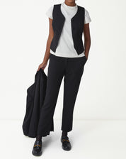 Look completo: modelo usando colete slim alfaiataria preto com camiseta branca e calça social preta, visual office-to-evening.