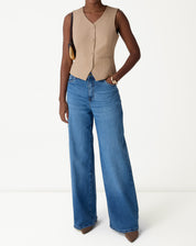 Foto frontal inteira do colete slim bege em modelo, destacando comprimento midi e corte ajustado