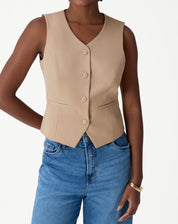 Colete slim alfaiataria bege sem mangas, vista frontal até o quadril com decote em V e botões forrados, modelo feminino