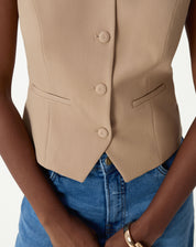 Vista traseira do colete slim bege mostrando costuras da modelagem e caimento estruturado em tecido plano