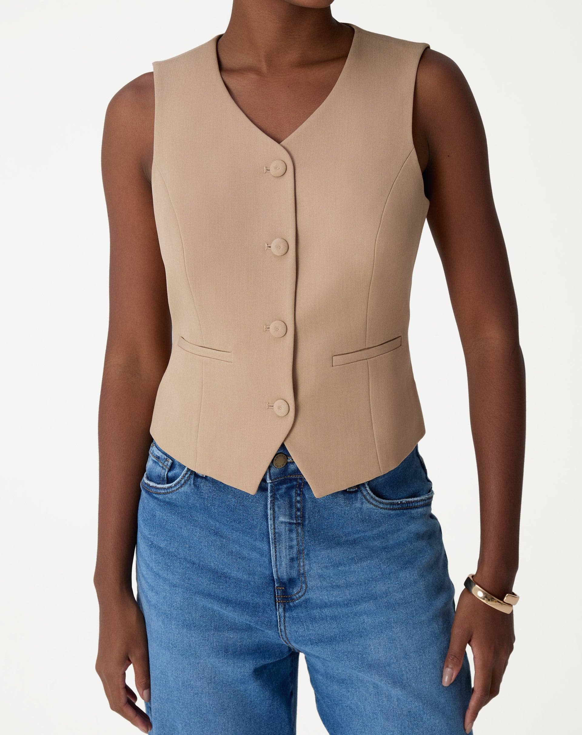 Close-up do painel frontal com botões forrados e bolsos embutidos do colete alfaiataria bege, detalhe de acabamento