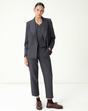 Conjunto de alfaiataria: modelo veste blazer sobre colete slim cinza, formando um look profissional.