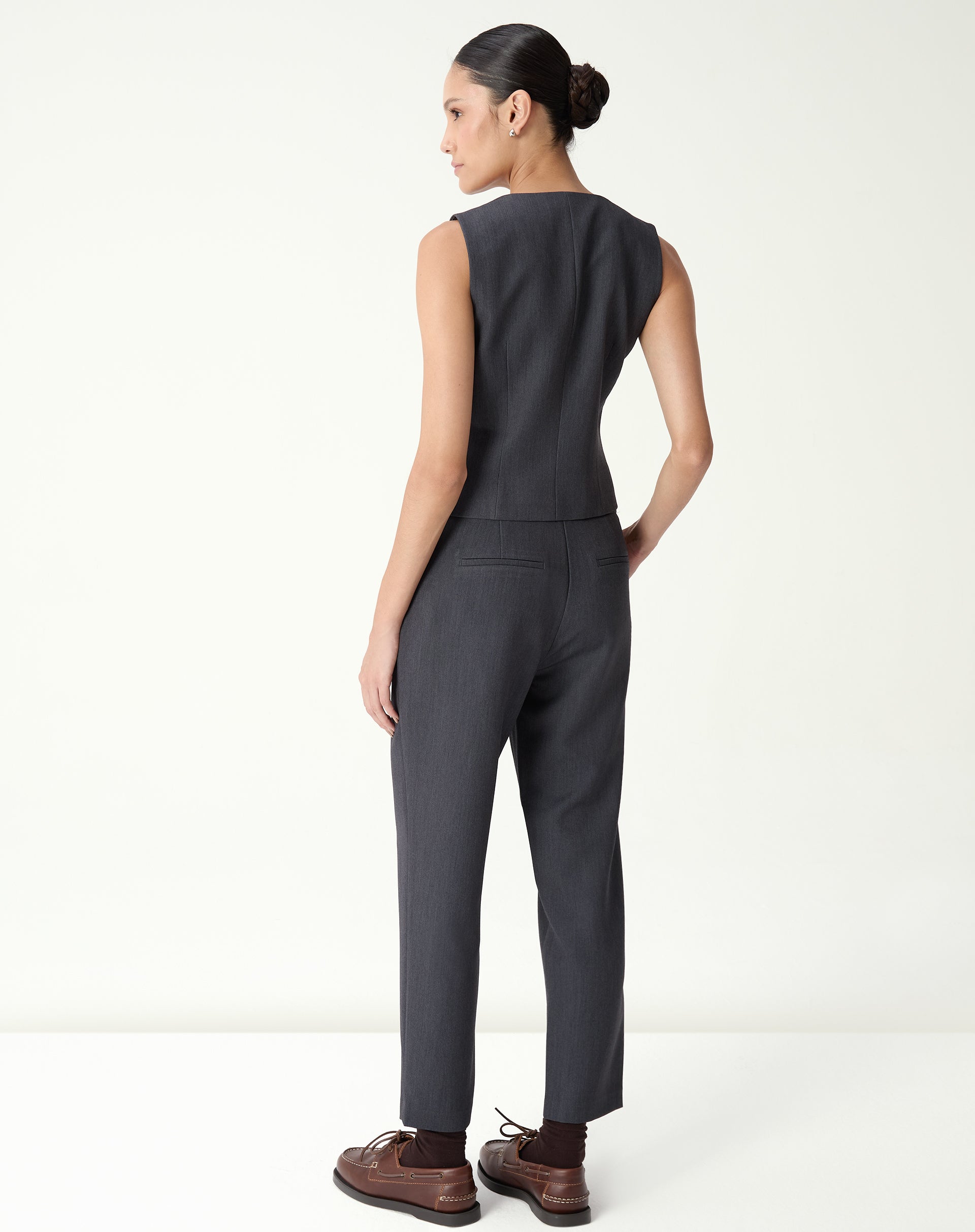 Vista traseira do colete slim alfaiataria cinza em modelo com caimento ajustado e costuras visíveis.