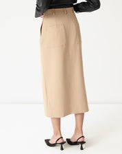 Vista frontal inferior da saia midi alfaiataria bege destacando a fenda frontal discreta e o caimento reto até o meio da canela