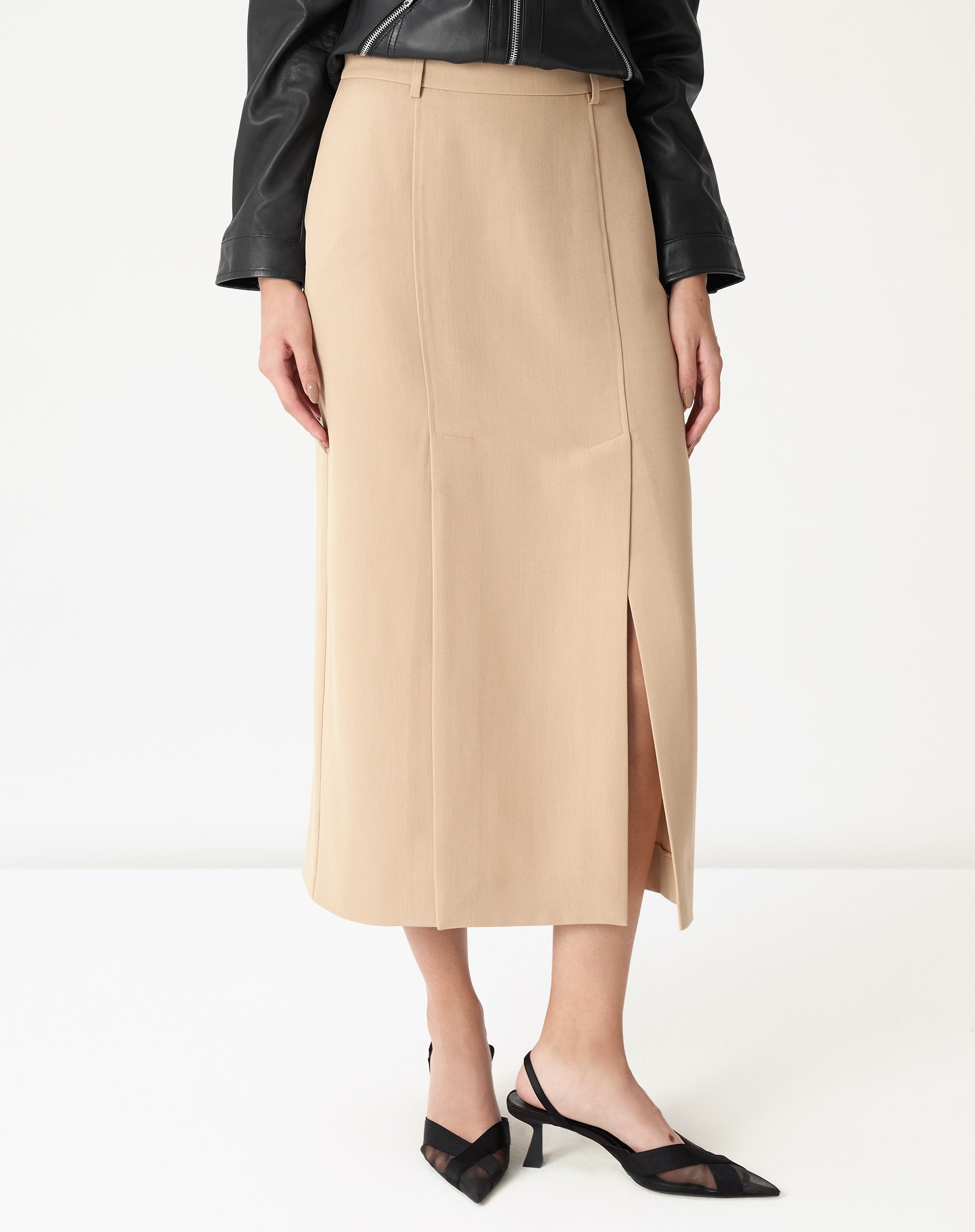 Close do cós médio e lateral da saia midi alfaiataria bege mostrando costura vertical, passante para cinto e textura do tecido plano