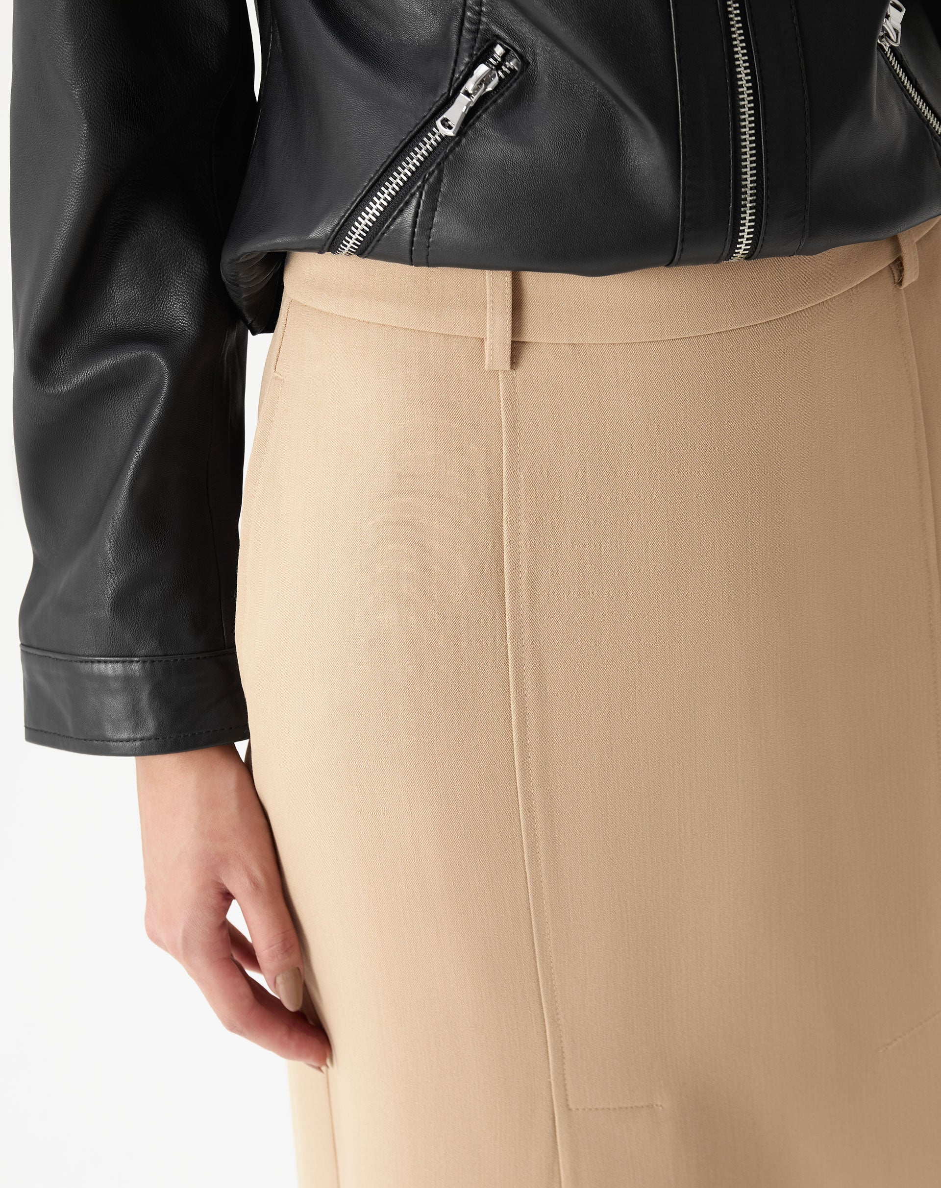 Detalhe do cós e passantes da saia midi bege em plano de estúdio, visão próxima do acabamento e ponto de costura central