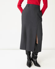 Detalhe frontal da saia midi cinza mostrando a fenda lateral e o caimento do tecido plano em close.