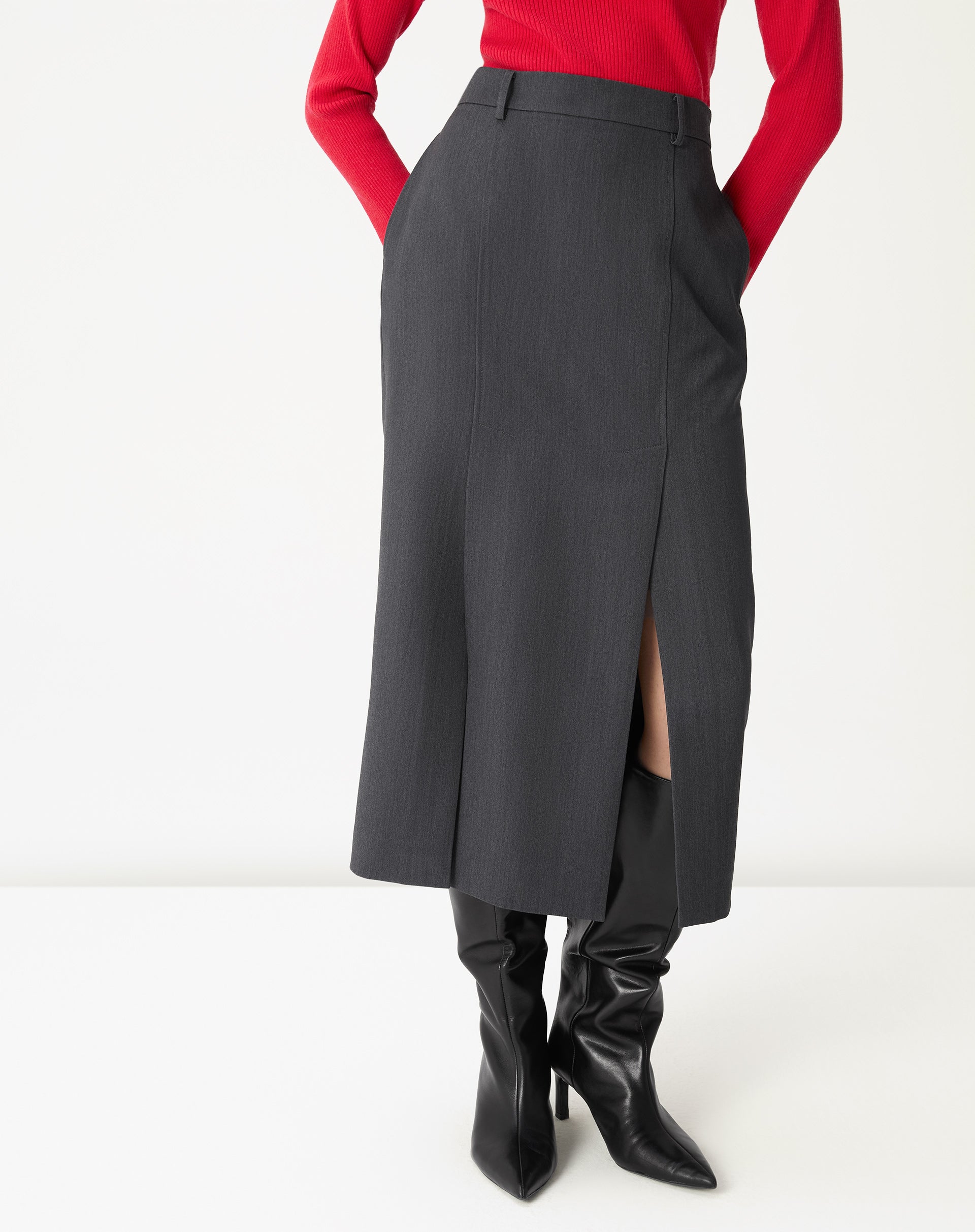Detalhe frontal da saia midi cinza mostrando a fenda lateral e o caimento do tecido plano em close.