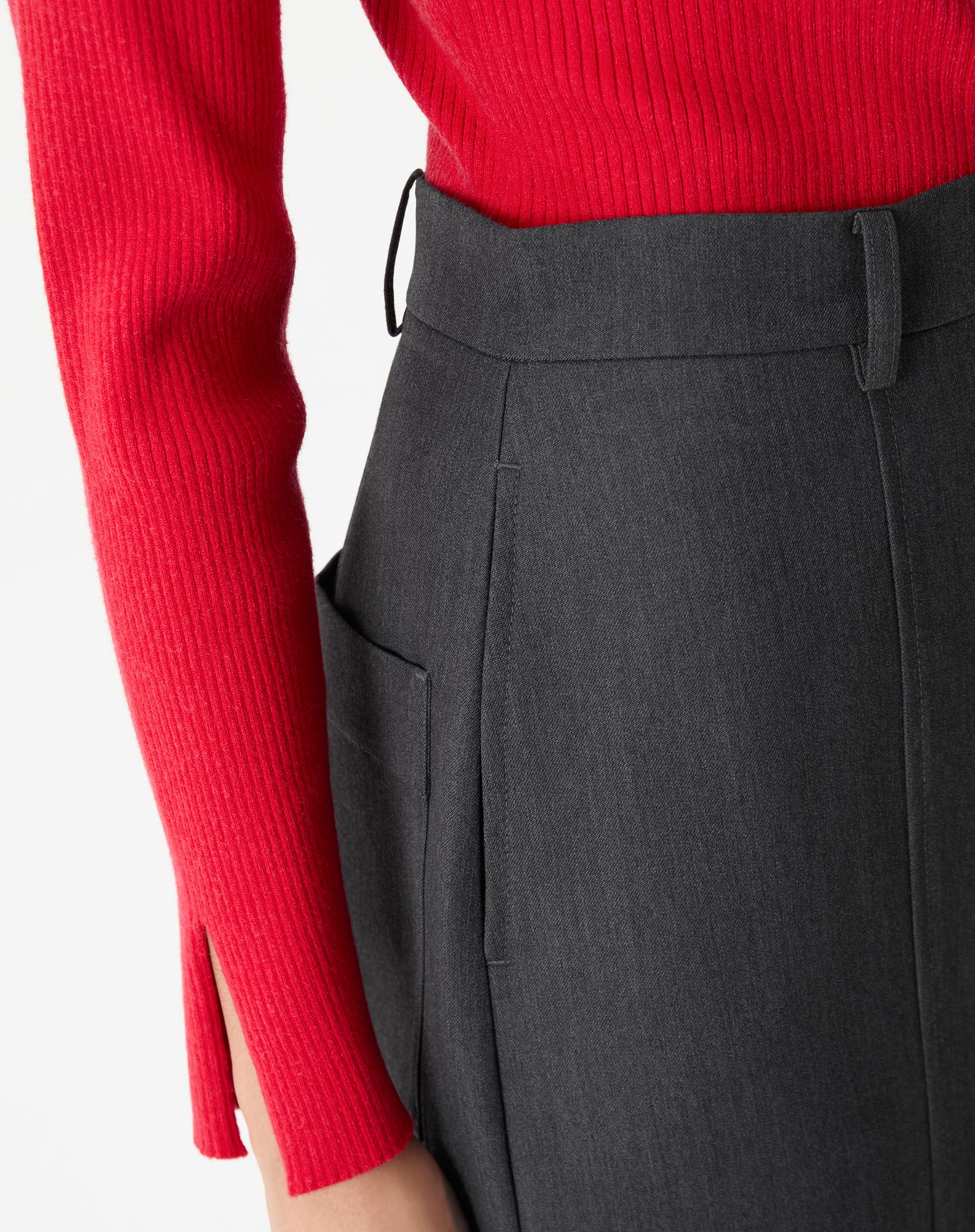 Close do cós e do bolso patch lateral da saia alfaiataria cinza, com passantes para cinto e costura limpa.