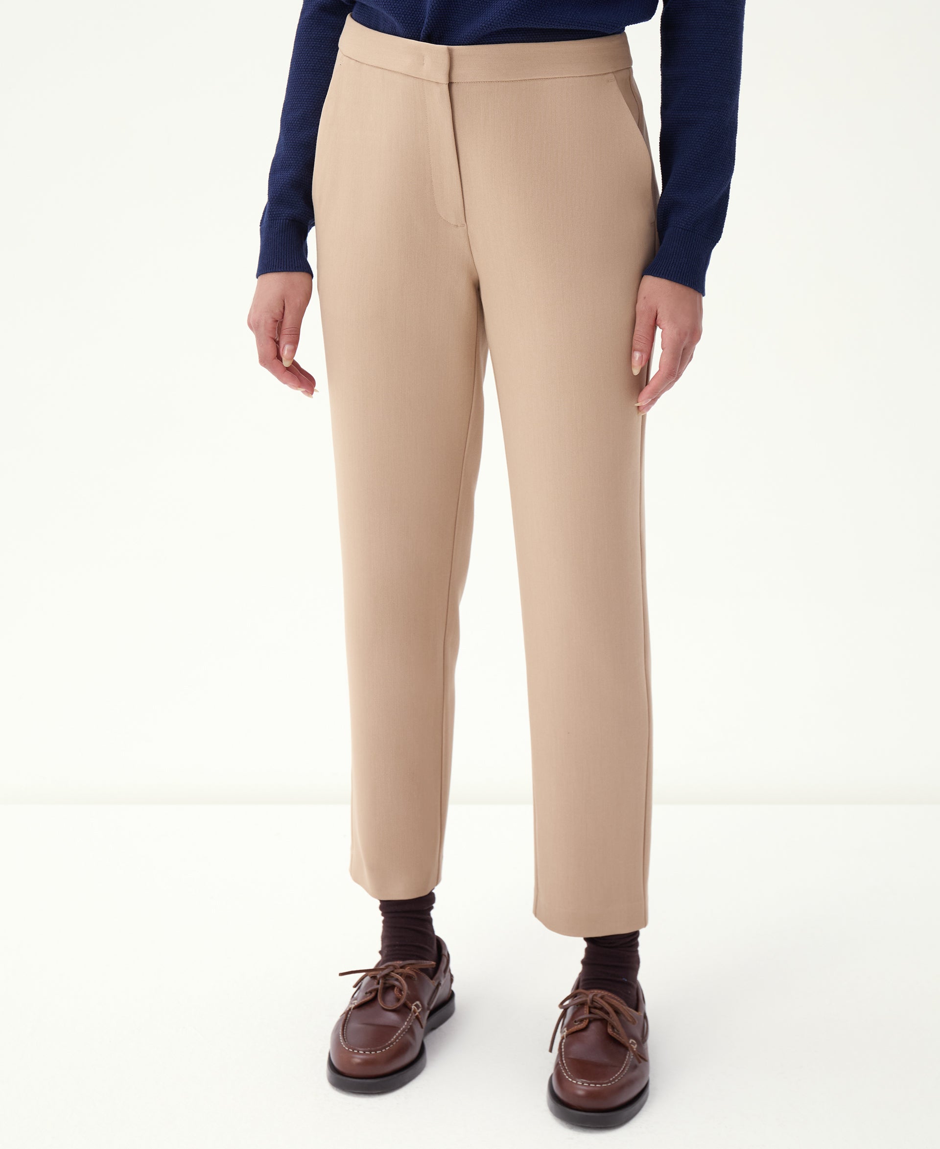 Imagem do cós e fecho da calça slim alfaiataria bege em close frontal, mostrando acabamento e caimento.