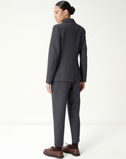 Close no cós baixo e região frontal da calça slim alfaiataria cinza, detalhe de costura e acabamento limpo