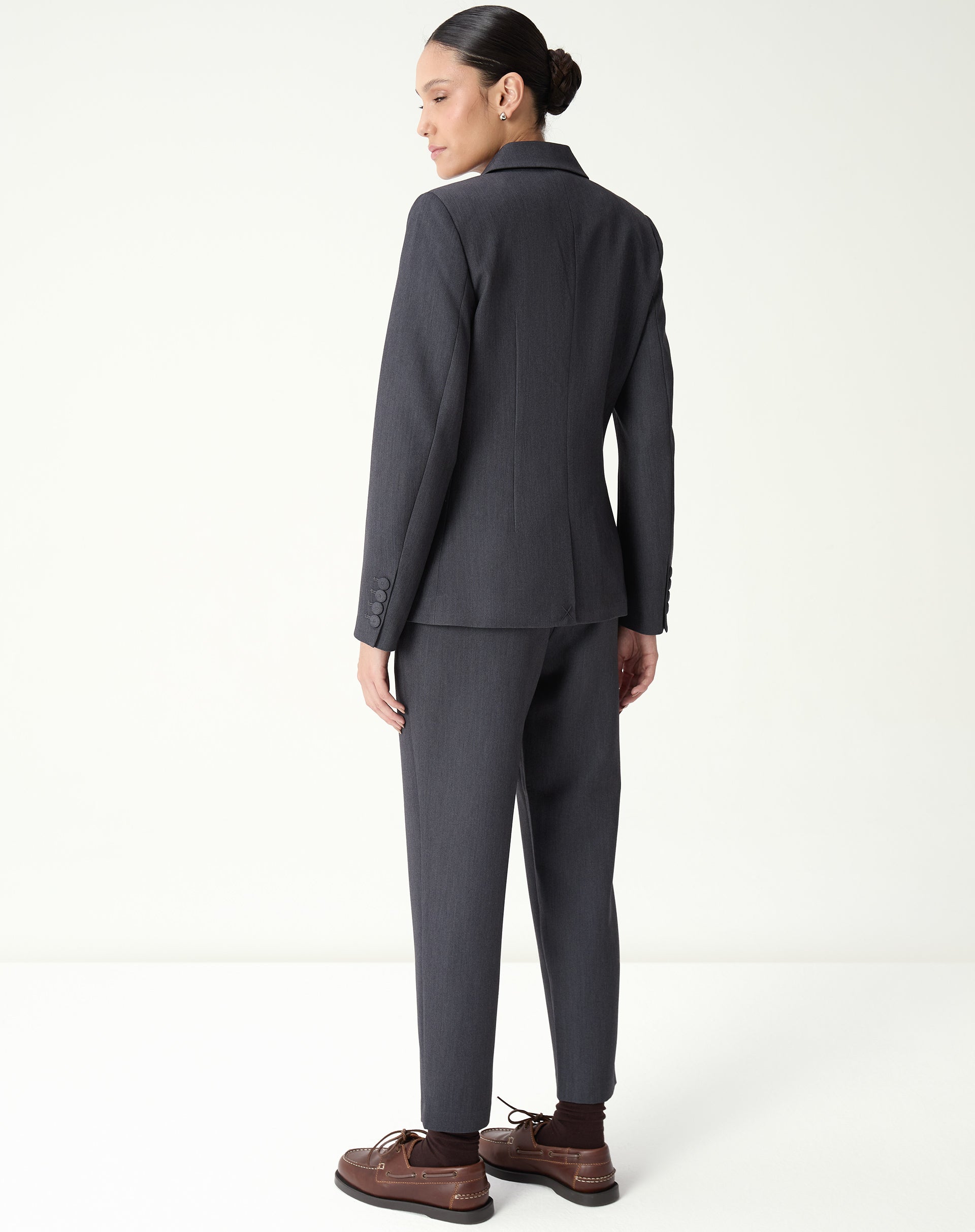 Close no cós baixo e região frontal da calça slim alfaiataria cinza, detalhe de costura e acabamento limpo