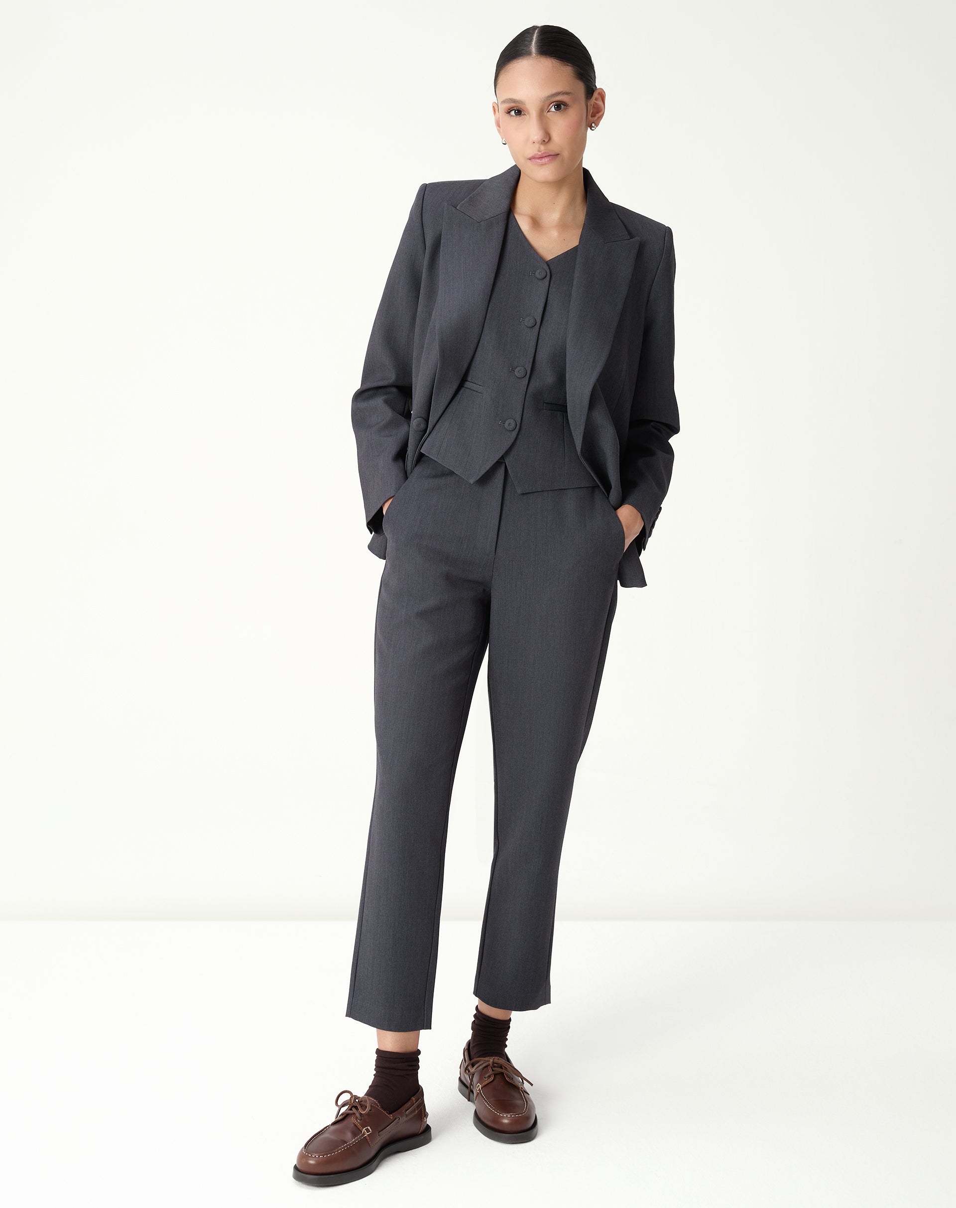 Calça Slim Alfaiataria cinza vista frontal em look completo com blazer e sapato marrom, modelagem slim e cós baixo