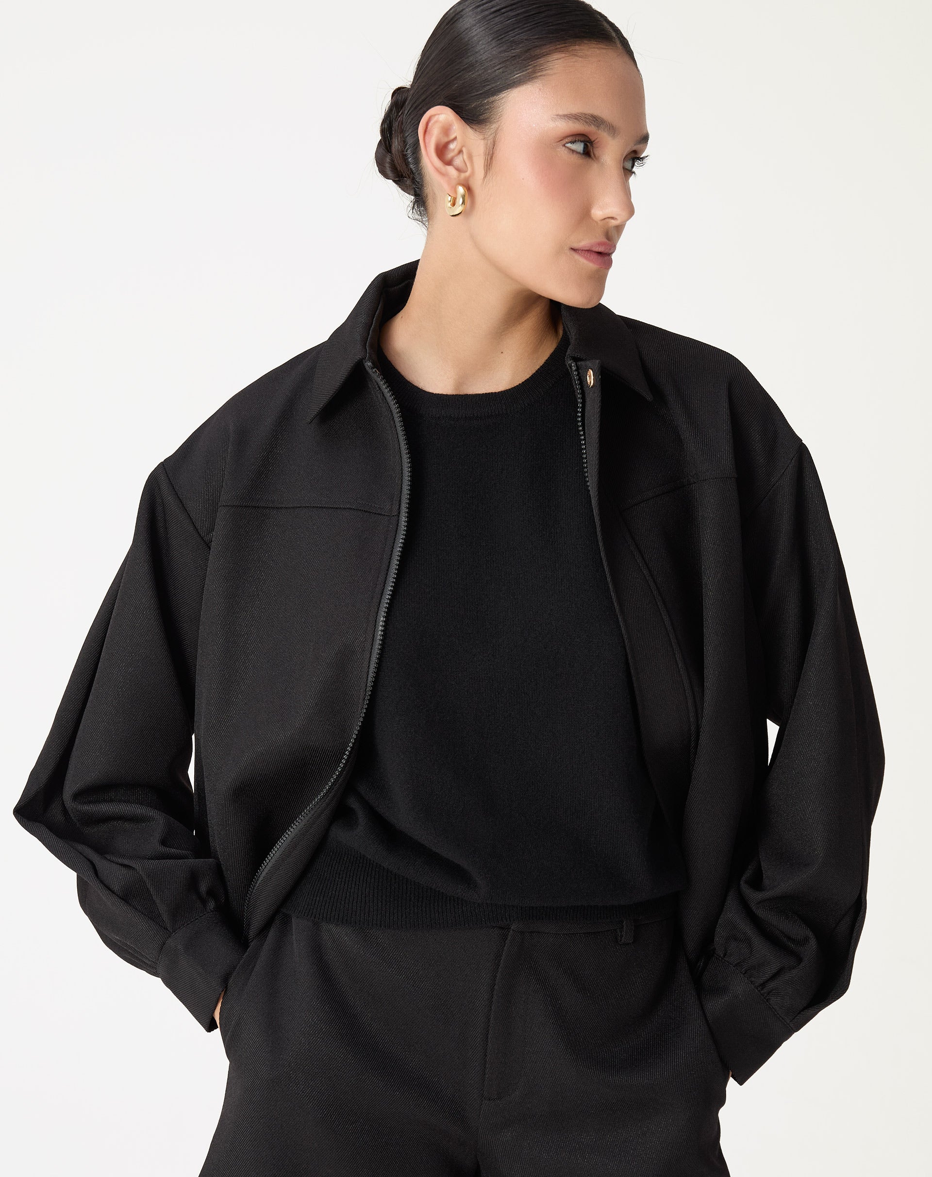 Casaco preto feminino com punhos largos, vista frontal 3/4 com zíper oculto e gola clássica - casaco alfaiataria em poliéster