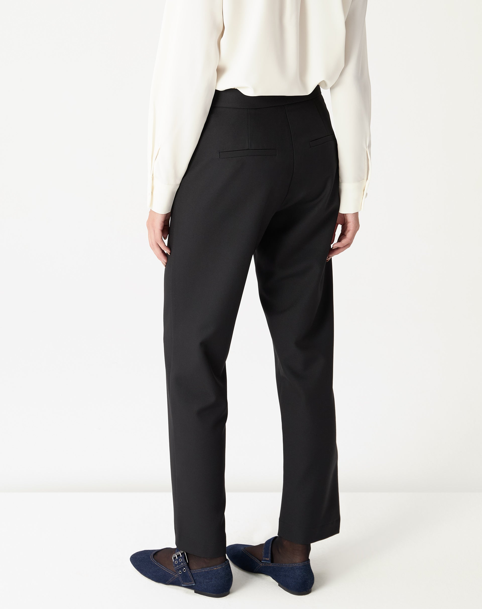 Vista traseira da calça alfaiataria preta em modelo, corte reto e comprimento longo