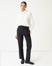 Calça alfaiataria preta vista frontal em modelo, cós alto e perna reta em comprimento longo