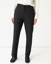 Calça preta vista frontal completa com camisa off-white e mocassim azul, silhueta reta