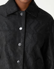 Detalhe de fechamento da jaqueta com botões de pressão em acabamento fosco.