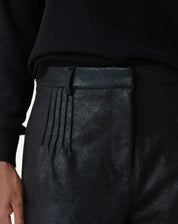 Flat lay do shorts metalizado preto com modelagem reta e bainha aplicada, destaque para o brilho discreto do tecido