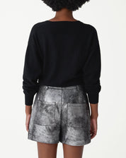 Detalhe lateral do shorts metalizado prata com acabamento texturizado e costura do bolso embutido