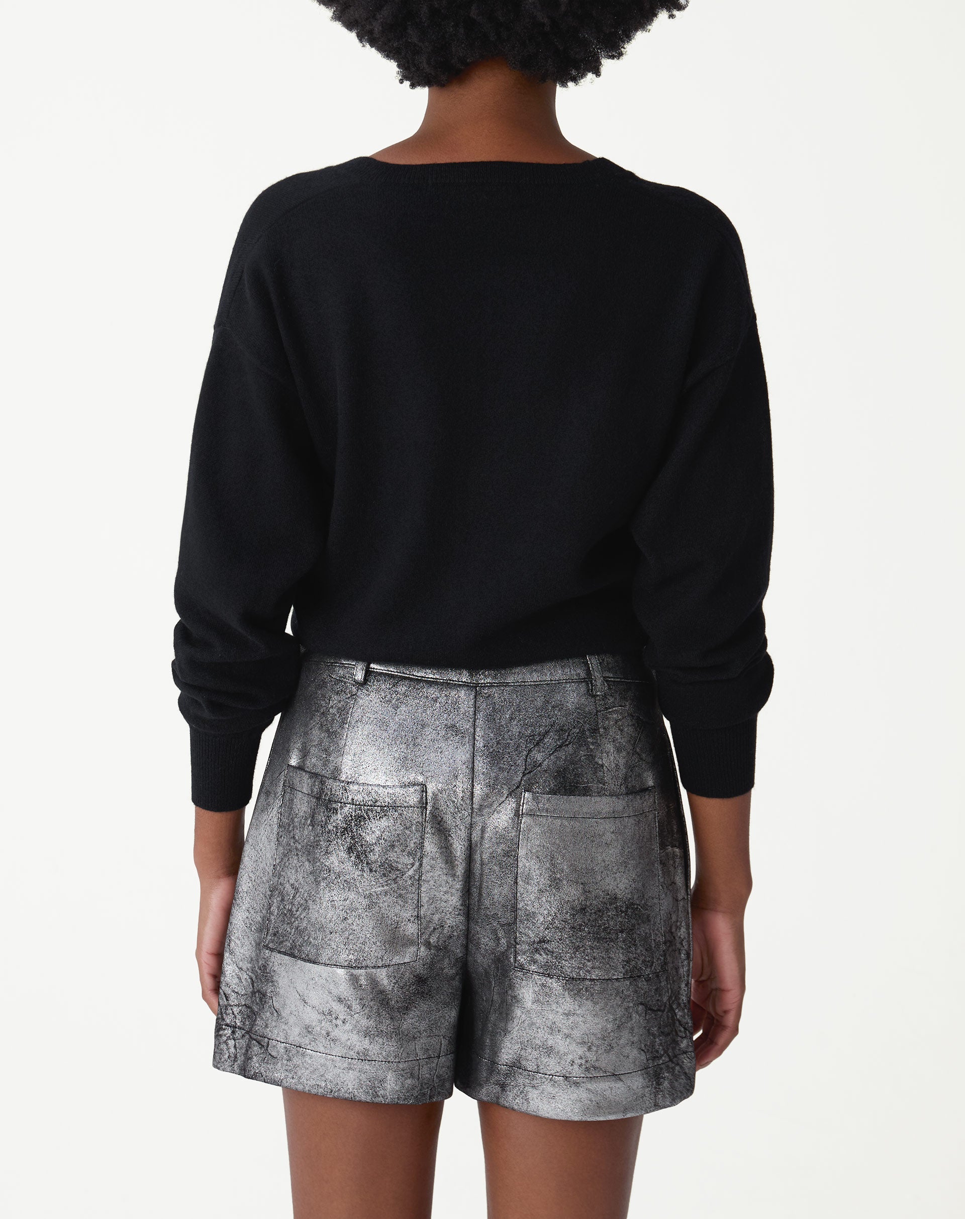 Detalhe lateral do shorts metalizado prata com acabamento texturizado e costura do bolso embutido