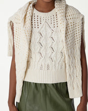 Visual traseiro da regata de tricô bege mostrando os detalhes vazados e barra canelada na parte posterior.