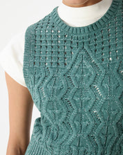 Close da frente da regata tricot verde evidenciando ponto diferenciado com tranças e pequenos vazados